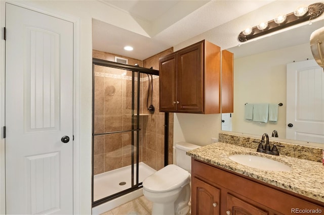 bathroom with tile patterned flooring, vanity, toilet, and walk in shower