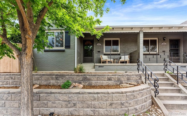 view of front facade featuring brick siding and a porch