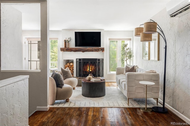 377 Pearl St Unit 5, Boulder, CO 80302 - living area with an AC wall unit, wood finished floors, plenty of natural light, a lit fireplace, and a textured wall