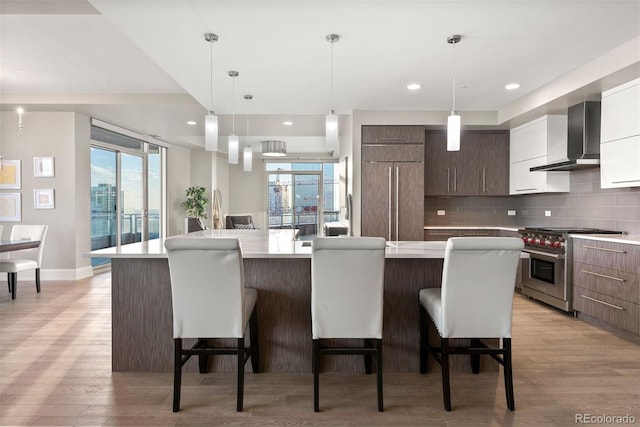 2001 Lincoln St Unit 2524, Denver, CO 80202 - kitchen featuring wall chimney exhaust hood, modern cabinets, high end stainless steel range, light countertops, and recessed lighting