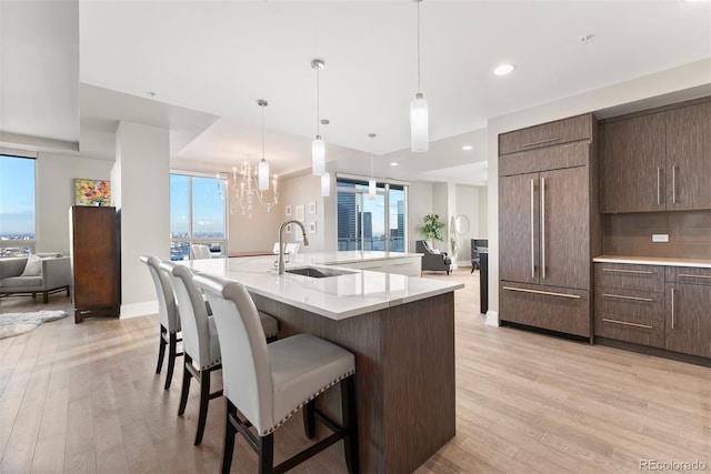 2001 Lincoln St Unit 2524, Denver, CO 80202 - kitchen featuring built in fridge, open floor plan, a sink, light wood-style floors, and a kitchen bar