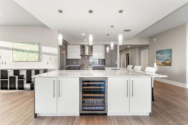 2001 Lincoln St Unit 2524, Denver, CO 80202 - kitchen featuring beverage cooler, wall chimney exhaust hood, a sink, baseboards, and built in refrigerator
