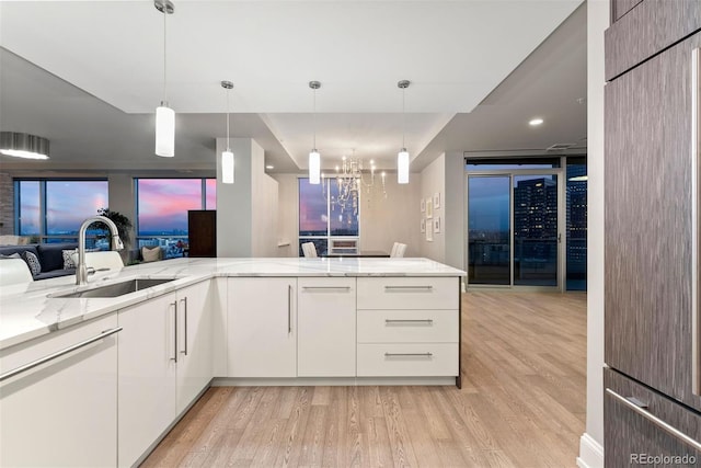 2001 Lincoln St Unit 2524, Denver, CO 80202 - kitchen featuring a sink, light wood-style flooring, open floor plan, and light stone countertops