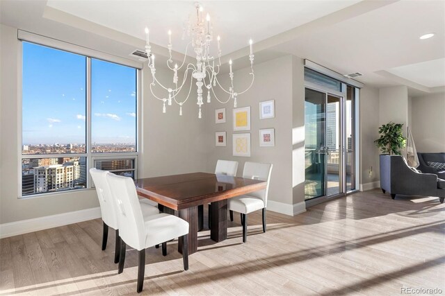 2001 Lincoln St Unit 2524, Denver, CO 80202 - dining area featuring wood finished floors, a chandelier, baseboards, and healthy amount of natural light