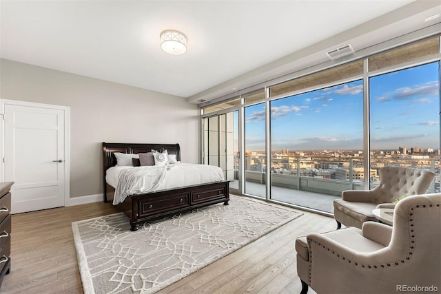2001 Lincoln St Unit 2524, Denver, CO 80202 - bedroom featuring access to exterior, wood finished floors, baseboards, and floor to ceiling windows