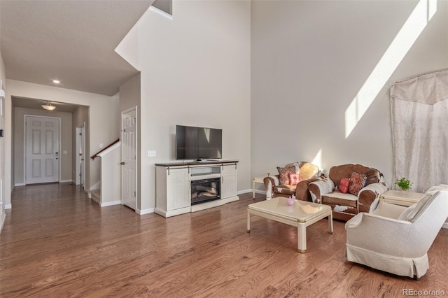 living room featuring recessed lighting, baseboards, and wood finished floors