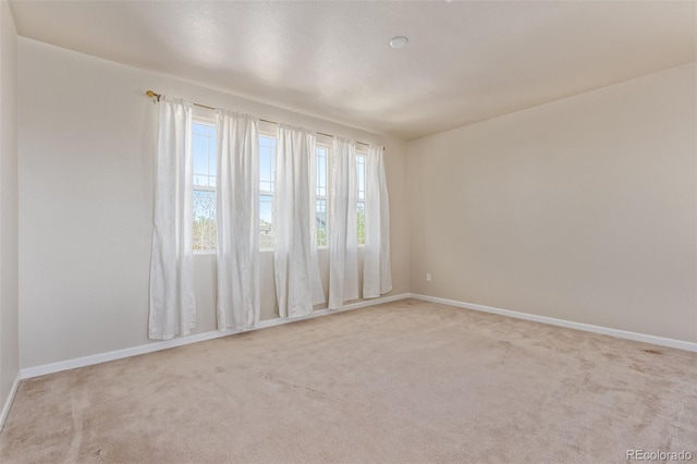 carpeted spare room with baseboards