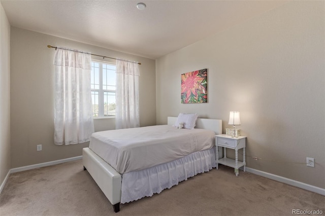 bedroom featuring light colored carpet and baseboards