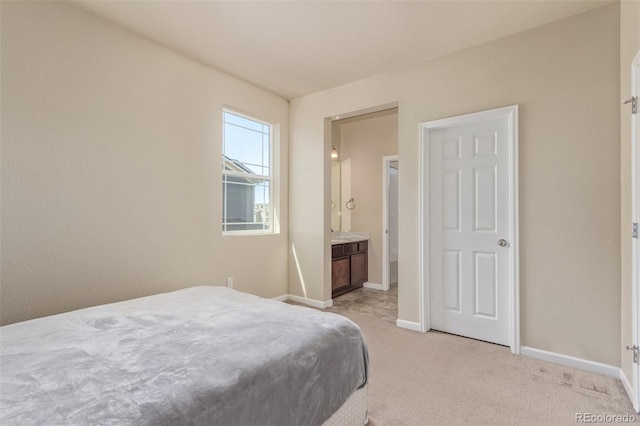 bedroom featuring light colored carpet, connected bathroom, and baseboards
