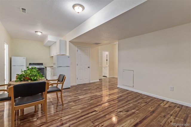 dining area with baseboards, visible vents, and wood finished floors