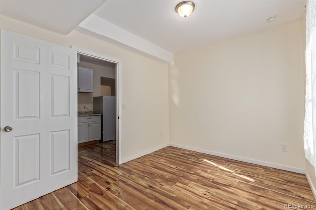 unfurnished room featuring wood finished floors and baseboards