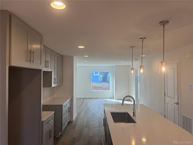 kitchen featuring visible vents, dark wood finished floors, light countertops, a sink, and recessed lighting