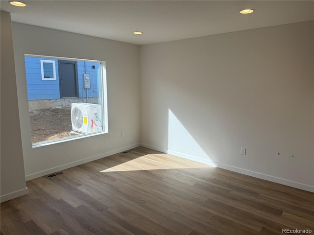 spare room with baseboards, visible vents, and wood finished floors