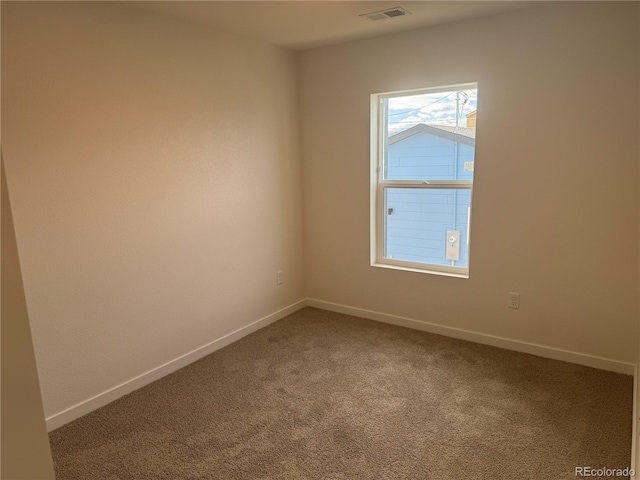 empty room featuring carpet floors, visible vents, and baseboards