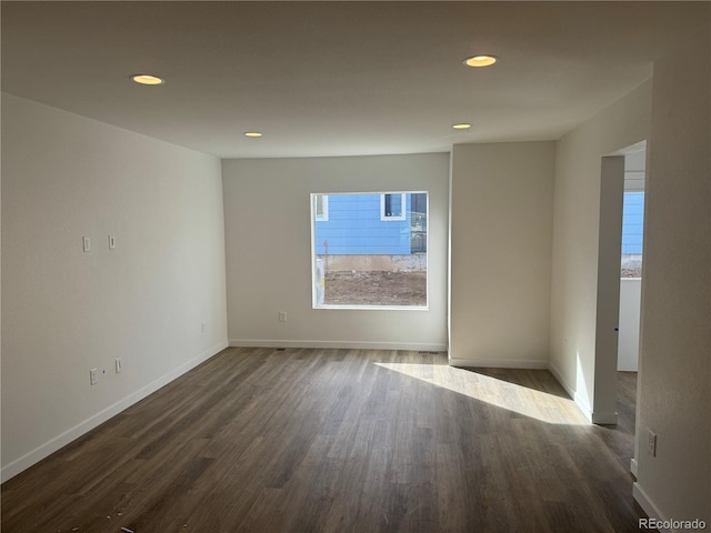 empty room featuring a wealth of natural light, dark wood-style flooring, and recessed lighting