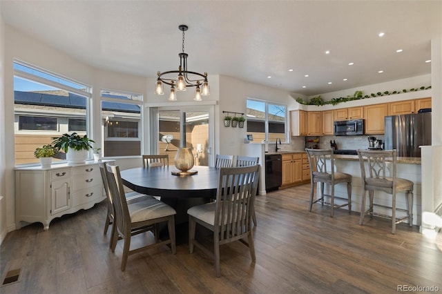 dining space featuring sink, a notable chandelier, and dark hardwood / wood-style flooring