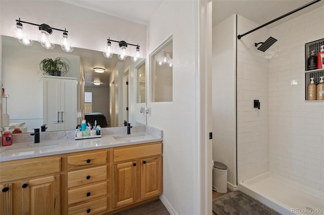 bathroom with vanity and a tile shower