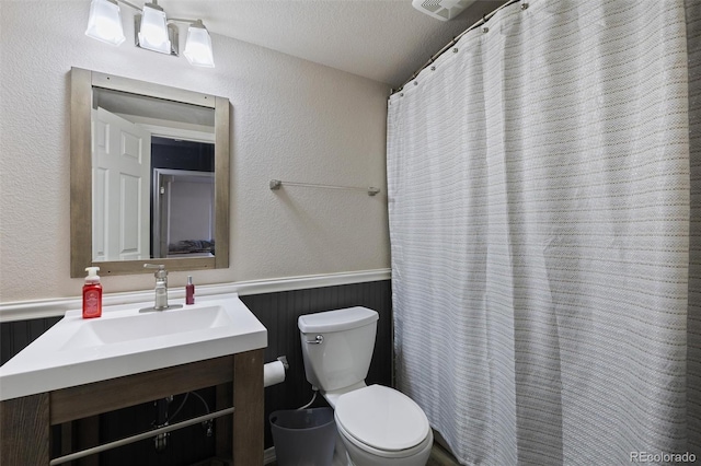 bathroom featuring vanity, toilet, and a textured ceiling