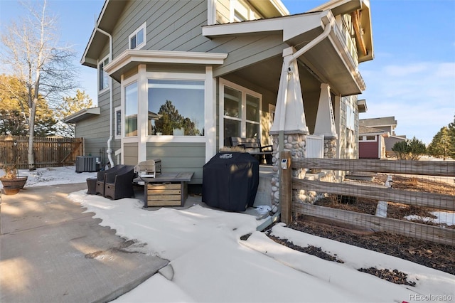 snow covered property with central AC unit