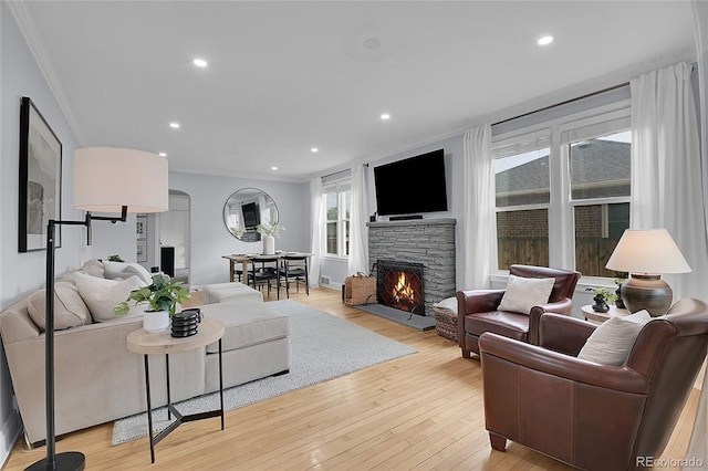 2212 Ingalls St, Edgewater, CO 80214 - living room featuring ornamental molding, a fireplace, light wood-style flooring, recessed lighting, and arched walkways