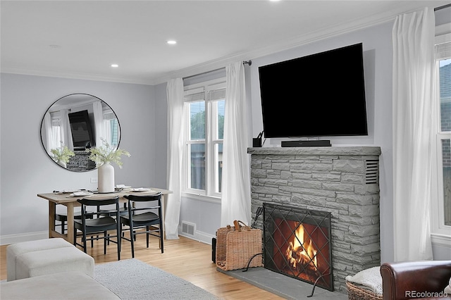 2212 Ingalls St, Edgewater, CO 80214 - living area featuring crown molding, wood finished floors, a stone fireplace, and recessed lighting