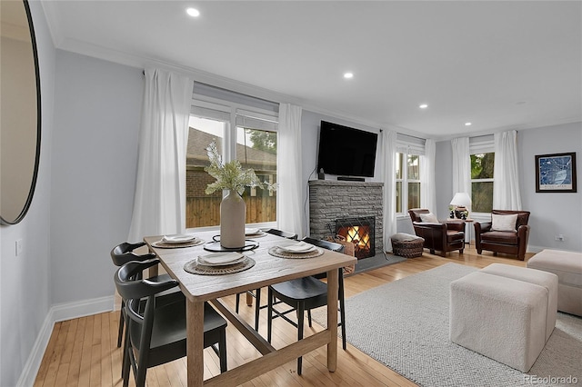 2212 Ingalls St, Edgewater, CO 80214 - dining space with a stone fireplace, light wood finished floors, recessed lighting, and ornamental molding