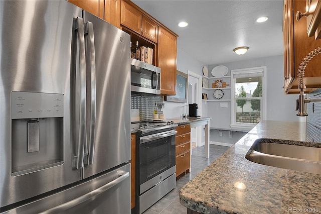 2212 Ingalls St, Edgewater, CO 80214 - kitchen featuring stainless steel appliances, open shelves, brown cabinetry, decorative backsplash, and dark tile patterned floors