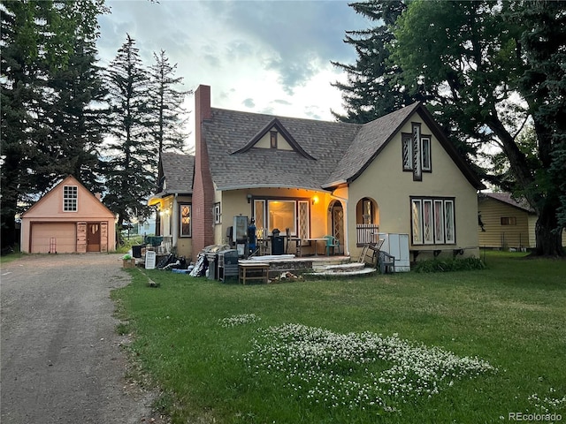 1069 US Highway 285, Monte Vista, CO 81144 - rear view of property featuring a chimney, stucco siding, an outbuilding, a garage, and a lawn