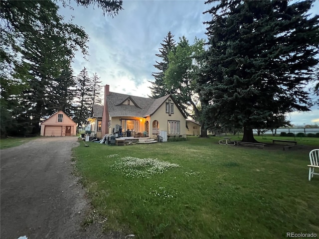 1069 US Highway 285, Monte Vista, CO 81144 - view of front of property with a chimney, an outbuilding, stucco siding, a garage, and a front lawn