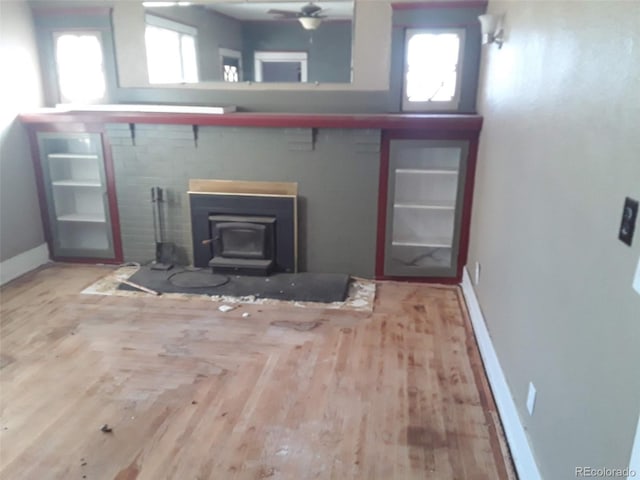 1069 US Highway 285, Monte Vista, CO 81144 - living area with a wood stove, wood finished floors, and ceiling fan