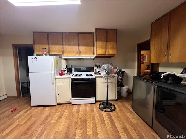 1069 US Highway 285, Monte Vista, CO 81144 - kitchen with gas range oven, freestanding refrigerator, light wood-style flooring, light countertops, and under cabinet range hood