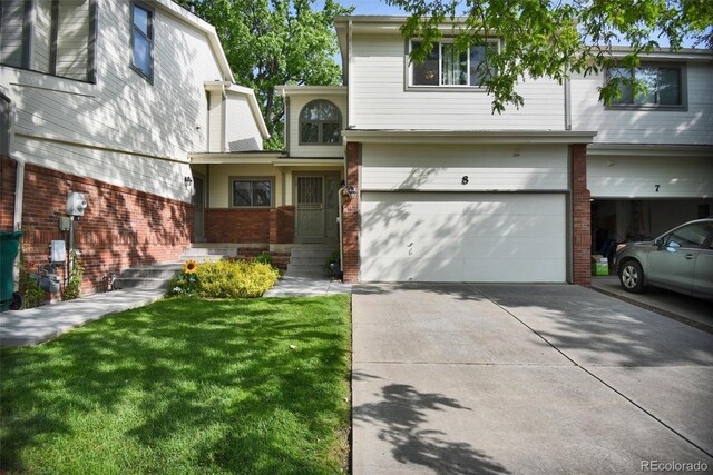 5283 Union Ct Unit 8, Arvada, CO 80002 - view of front of property with brick siding, a garage, concrete driveway, and a front lawn