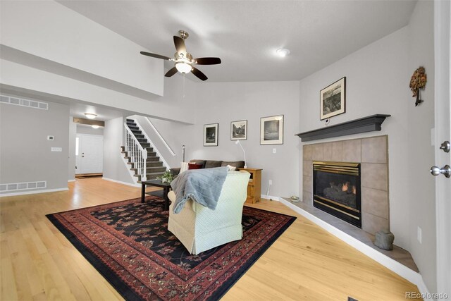 5283 Union Ct Unit 8, Arvada, CO 80002 - living room with stairway, light wood finished floors, a tiled fireplace, a ceiling fan, and lofted ceiling