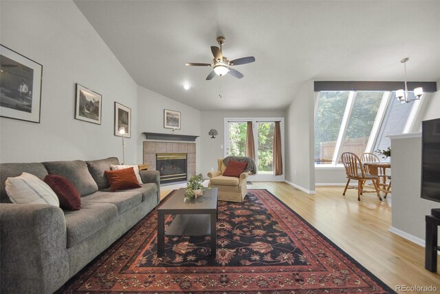 5283 Union Ct Unit 8, Arvada, CO 80002 - living room with light wood finished floors, a ceiling fan, a chandelier, a tile fireplace, and lofted ceiling