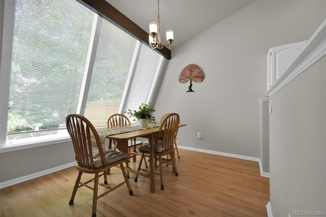 5283 Union Ct Unit 8, Arvada, CO 80002 - dining area featuring light wood finished floors, a chandelier, baseboards, and vaulted ceiling