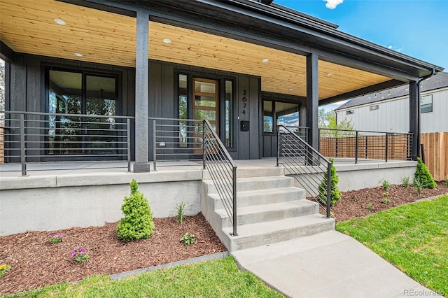 view of exterior entry featuring covered porch