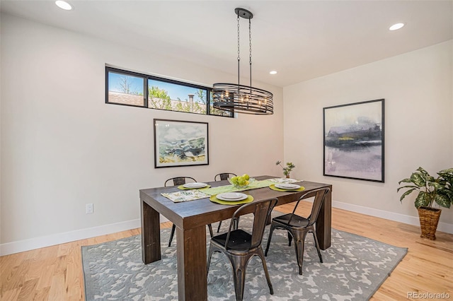 dining area featuring light hardwood / wood-style flooring and a notable chandelier