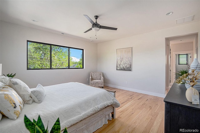 bedroom featuring multiple windows, ceiling fan, and light hardwood / wood-style flooring