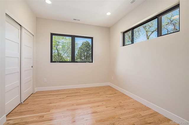 unfurnished bedroom with a closet and light hardwood / wood-style floors