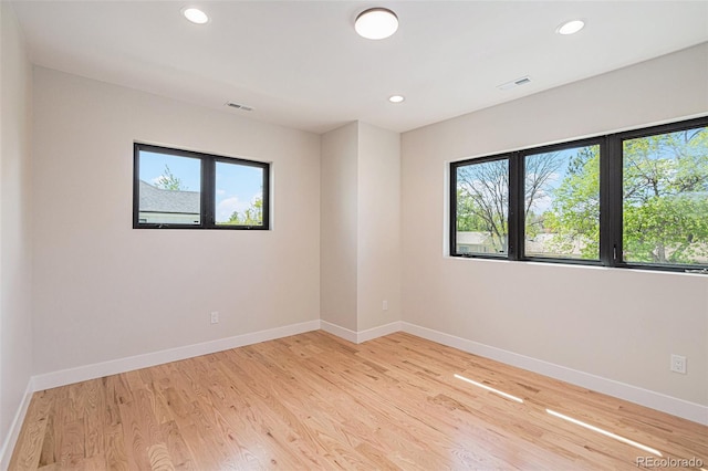 empty room with a healthy amount of sunlight and light hardwood / wood-style floors