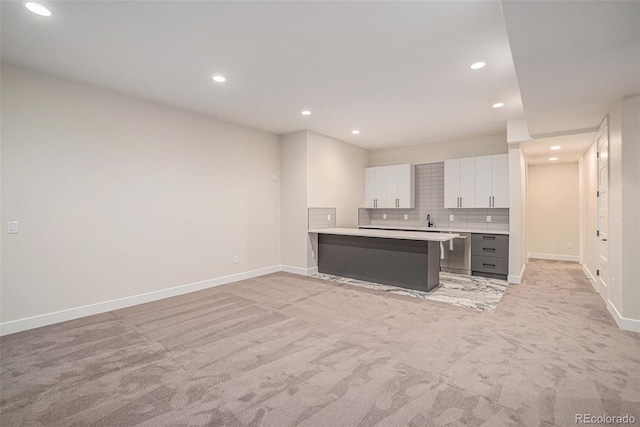 kitchen with light carpet, backsplash, white cabinetry, gray cabinets, and kitchen peninsula