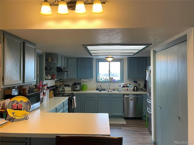 kitchen with light countertops, a sink, black range with electric cooktop, dishwasher, and a peninsula