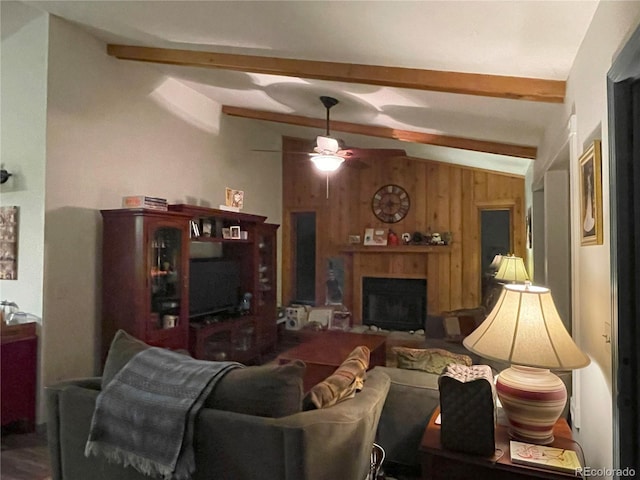 living room with vaulted ceiling with beams, ceiling fan, and wood walls