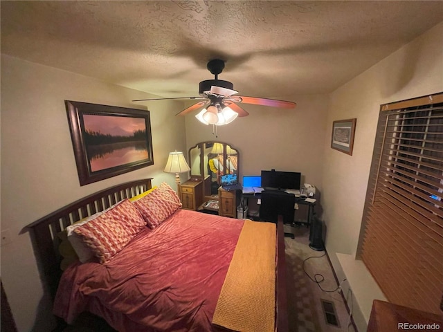 carpeted bedroom featuring ceiling fan and a textured ceiling