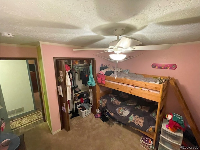 bedroom featuring carpet, a closet, a ceiling fan, and a textured ceiling