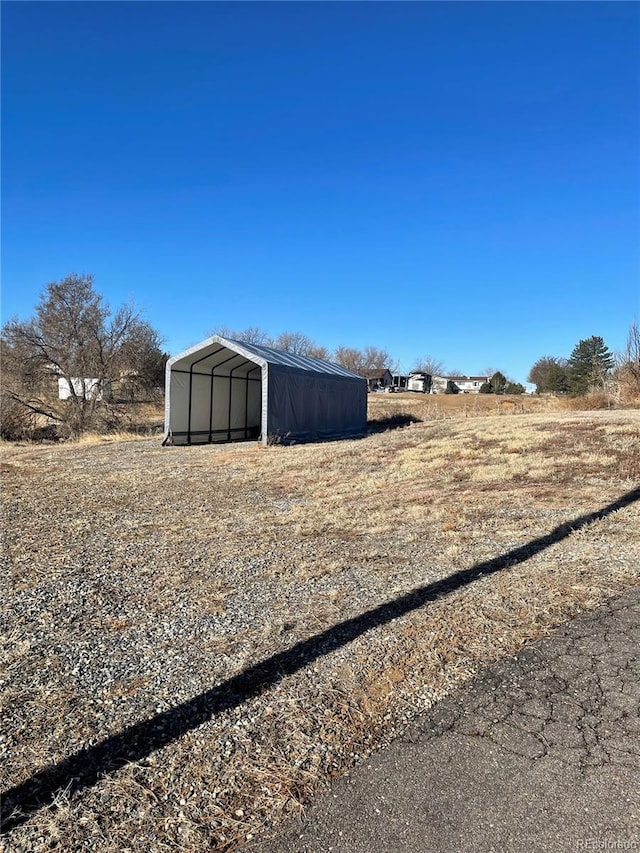 view of yard featuring a carport, an outbuilding, and a pole building