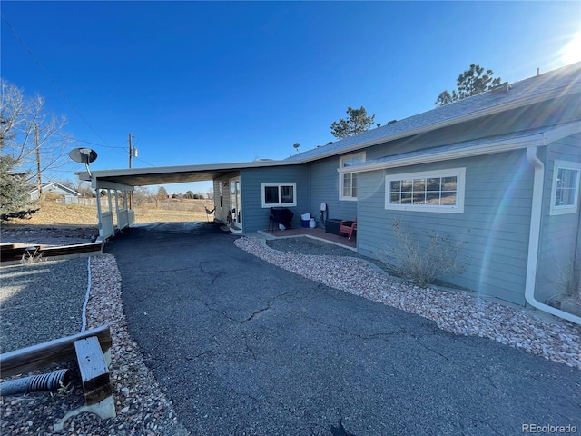 rear view of house featuring an attached carport and driveway