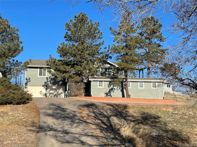 view of front facade with aphalt driveway and an attached garage