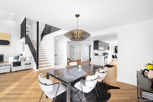 dining area with light hardwood / wood-style flooring and a chandelier