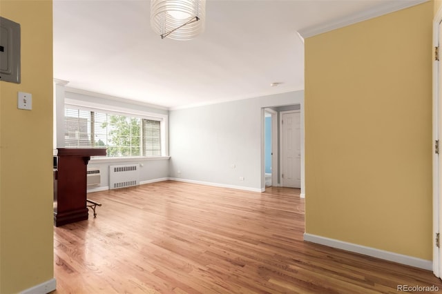 1450 Albion St Unit 204, Denver, CO 80220 - unfurnished living room featuring radiator, crown molding, and light wood-type flooring